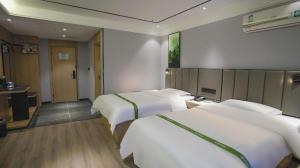 Voodi või voodid majutusasutuse GreenTree Inn LiaoCheng LinQing HaiShan Building Express Hotel toas