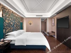 a bedroom with a large bed and a wall mural at Metropolo Hotel Financial Street Wanda Plaza in Fuzhou