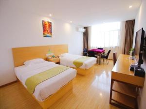 a hotel room with two beds and a desk at GreenTree Alliance Suzhou Zhangjiagang Nanfeng Town Hotel in Zhangjiagang +77 photos