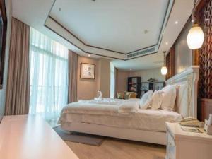 ein Schlafzimmer mit einem großen Bett und einem großen Fenster in der Unterkunft Excemon Beach Hotel Beihai in Beihai + 248 Fotos