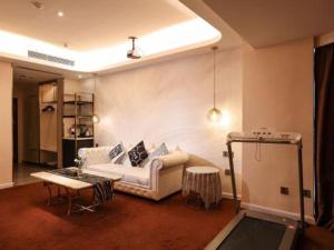 a living room with a couch and a table at Mandolin Intelligent Hotel Jinagmen in Jiangmen