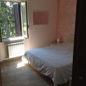 ein Schlafzimmer mit einem Bett und einem großen Fenster in der Unterkunft Carteo 2016 in Sutri