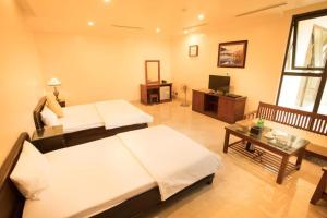 a large room with two beds and a television at Lakeside Hotel Nam Dinh in Như Thức