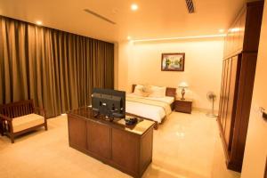a living room with a couch and a tv in a room at Lakeside Hotel Nam Dinh in Như Thức