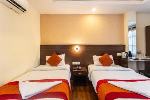 a hotel room with two beds with orange pillows at Hotel Sapana Garden Thamel in Kathmandu