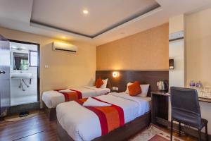 a hotel room with two beds and a chair at Hotel Sapana Garden Thamel in Kathmandu