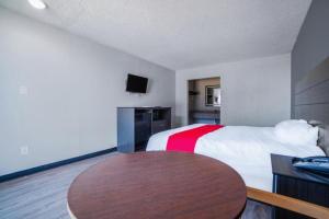a hotel room with a bed and a table at Hotel Comfort Stay by OYO Texarkana East, AR I-30 in Whatley