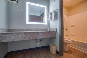 a bathroom with a sink and a toilet and a mirror at Hotel Comfort Stay by OYO Texarkana East, AR I-30 in Whatley +87 photos