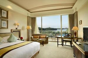 a hotel room with a bed and a large window at Dongguan MCB Lake Hotel in Dongguan