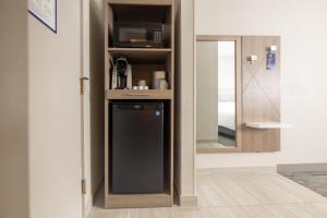 a kitchen with a small refrigerator and a mirror at Holiday Inn Express Frackville Hotel By IHG in Frackville