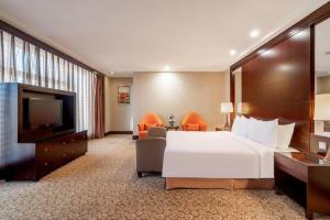 a hotel room with a large bed and a flat screen tv at Golden Eagle Summit Hotel Downtown in Nanjing