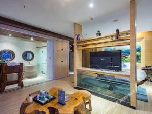 a living room with a large aquarium in the middle of it at Huangma Holiday Nanhai Museum Hotel in Haikou