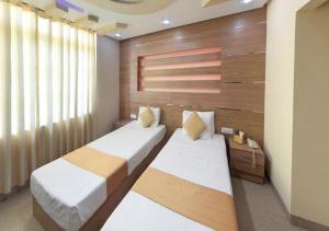 two beds in a bedroom with a wall at Hotel Royal Castle in Ettukala +38 photos