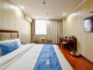 une chambre avec un grand lit et un bureau dans l'établissement GreenTree Inn Wuxi Changjiang North Road Jincheng Road Express Hotel, à Fangqian 178 autres photos