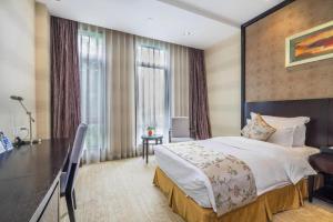 a hotel room with a large bed and a desk at Hangzhou Xixi Nade Runzeyuan Hotel in Hangzhou +276 photos