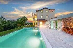 a villa with a swimming pool in front of a house at Villa Demetra in Motovun
