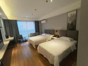 a hotel room with two beds and a television at GreenTree Inn Yangzhou Baoying South Anyi Road Express Hotel in Baoying +109 photos