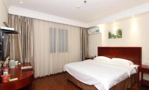 a bedroom with a large white bed in a room at GreenTree Inn Yangzhou Baoying South Anyi Road Express Hotel in Baoying