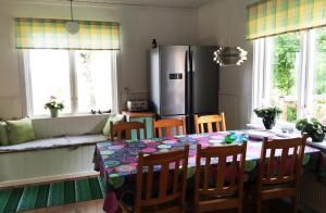 een keuken met een tafel met stoelen en een koelkast bij Villa Insikt Pensionat & Kursgård in Burträsk