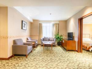 a hotel room with a bed and a living room at Xiamen Fortune Hotel in Xiamen