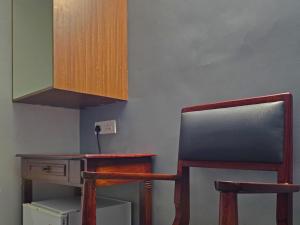 a kitchen with a desk and two chairs and a cabinet at Cliff End Beach Stay in Kappil