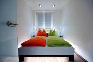 łóżko z kolorowymi poduszkami w pokoju w obiekcie Apartment Giuliano Vienna w Wiedniu