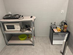 a small kitchen with a microwave on a table at Kwatera przed remontem BEZ zlewu w części kuchennej łazienka sprawna ale PRZED REMONTEM in Gdynia