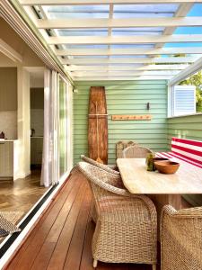 a dining room with a table and wicker chairs at Sunbird Suite by Stay Noosa in Noosa Heads