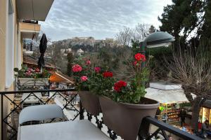 a balcony with flowers in pots on a balcony at DL-Hospitality@Adrianou 7 in Athens