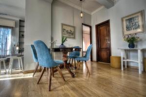 ein Esszimmer mit blauen Stühlen und einem Tisch in der Unterkunft DL-Hospitality@Adrianou 7 in Athen