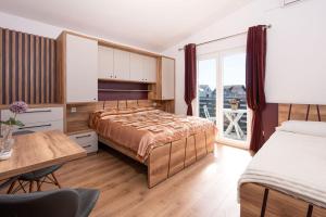 a bedroom with two beds and a desk and a table at Apartments & Rooms Meštrov in Vodice