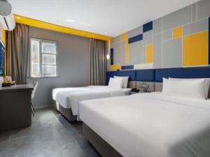 ein Hotelzimmer mit zwei Betten und einem Schreibtisch in der Unterkunft 7 Days Inn Changsha Pedestrian Street Nanmenkou Metro Station in Changsha + 97 Fotos
