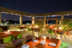 a restaurant with tables and chairs at night at Treebo Tryst Grand Emerald in Pune