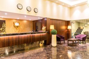 a lobby of a hotel with clocks on the wall at Treebo Tryst Grand Emerald in Pune