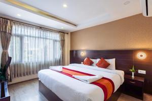 a bedroom with a large bed and a window at Hotel Sapana Garden Thamel in Kathmandu