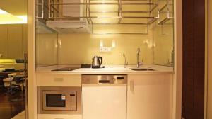 une cuisine avec un évier et un micro-ondes dans l'établissement Nanjing YuTimes Hotel, à Nankin