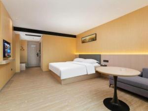 a bedroom with a bed and a table and a couch at Borrman Hotel Guangzhou Tianhe Tangdong Subway Station Convention and Exhibition Center in Guangzhou +162 photos