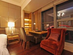 a bedroom with a bed and a desk and a chair at Nanjing YuTimes Hotel in Nanjing