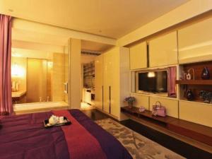 a bedroom with a bed and a tub and a television at Nanjing YuTimes Hotel in Nanjing