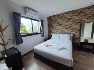 a bedroom with a bed and a brick wall at Rainbow Sky Hotel Samet in Ko Samed +166 photos