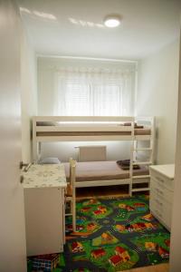 a small room with two bunk beds and a rug at Apartman MAJNA in Modriča