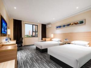 a hotel room with two beds and a television at City Comfort Inn Xiaogan Chengzhan Road in Xiaogan +120 photos