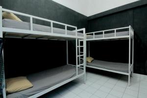 two bunk beds are in a room with a wall at Hostel Backpackers 44 in Yogyakarta