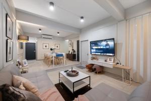 Una sala de estar con un sofá y un televisor. en 4BR house MRT subway 250m Chatujak Market wi-fi, en Bangkok
