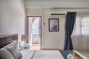 1 dormitorio con 1 cama y puerta a un balcón en 4BR house MRT subway 250m Chatujak Market wi-fi, en Bangkok