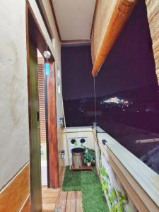 a balcony with grass and a pot of plants at Hanki Guest House syariah in Gadok 1