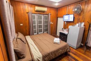ein kleines Schlafzimmer mit einem Bett und einem Kühlschrank in der Unterkunft Mossview Resort in Khao Kho