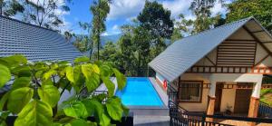 an image of a house with a swimming pool at Evaara Resorts in Anachal