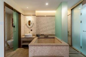 a bathroom with a tub and a sink and a toilet at Poltton International Service Apartment Fujian Changtai Mayangxi in Zhangzhou +98 photos