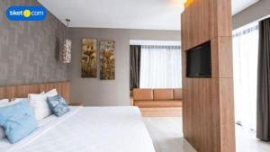 a bedroom with a large bed with a tv on it at D'Anaya Hotel Bogor in Bogor